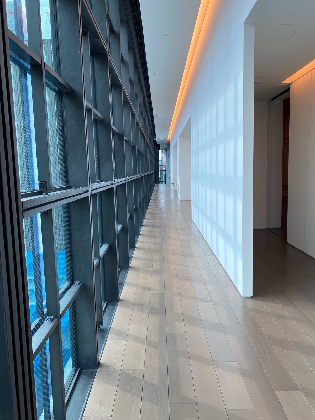 A modern glass corridor with daylight and clear sightlines.