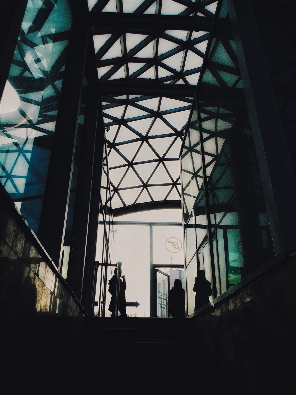 People moving through a geometric public atrium.